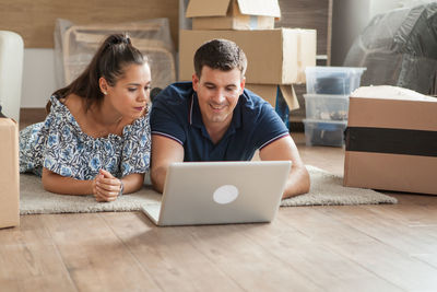 Portrait of smiling young woman using laptop at home