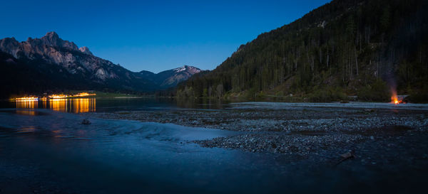 Scenic view of lake against mountains at dusk