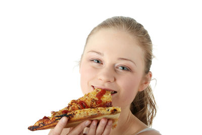 Portrait of smiling woman eating ice cream against white background