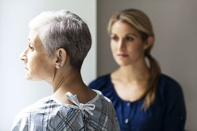 Thoughtful mother and daughter standing in hospital
