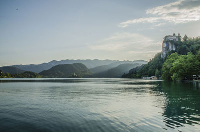 Scenic view of lake by mountains against sky