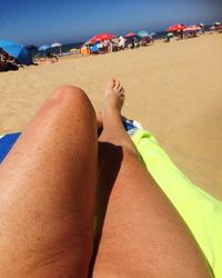 Low section of people relaxing on beach