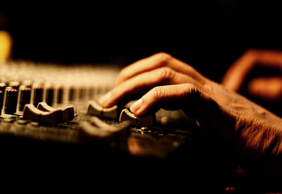 Cropped hands of person playing synthesizer