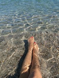 Low section of woman relaxing in river