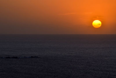 Scenic view of sea against orange sky