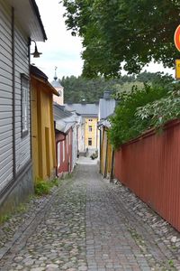 Footpath amidst buildings against sky