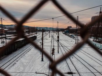 Railroad tracks seen through chainlink fence