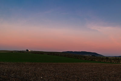 Scenic view of field against sky during sunset