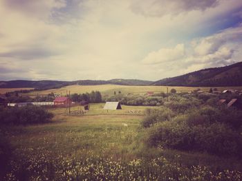 Scenic view of field against cloudy sky