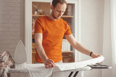 Man looking at camera while standing on bed at home