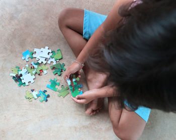 High angle view of woman playing with tattoo on floor