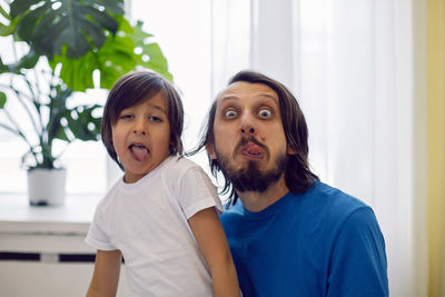 Father and son having fun sitting by the window