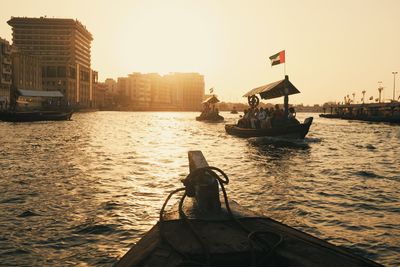 Nautical vessel on river against sky during sunset