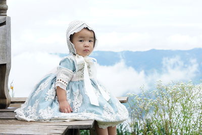 Portrait of young woman standing against sky