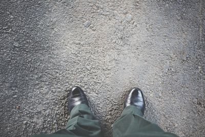 Low section of man standing on road