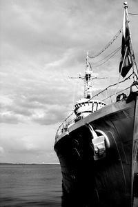 Low angle view of ship moored on sea against cloudy sky