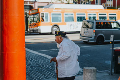 Side view of man standing on street in city