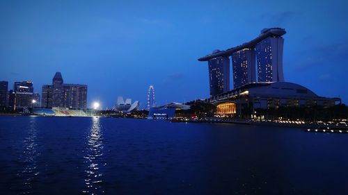 Marina bay sands in city against sky at dusk