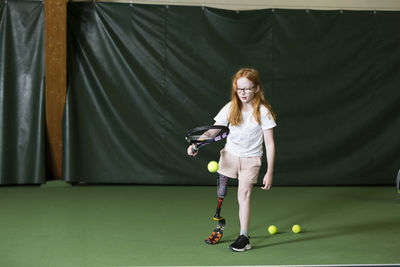 Girl with artificial leg playing tennis