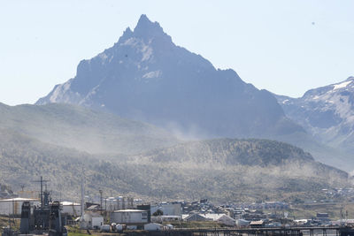 Aerial view of townscape by mountains against sky