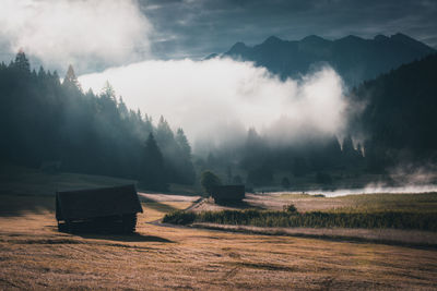 Scenic view of hut on land against sky