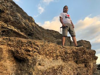 Low angle view of man standing on rock