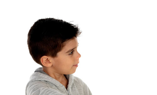 Close-up portrait of boy looking away against white background
