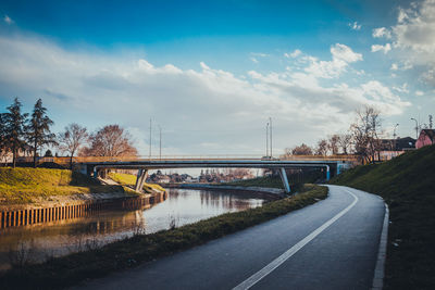 Bridge over river against sky in city