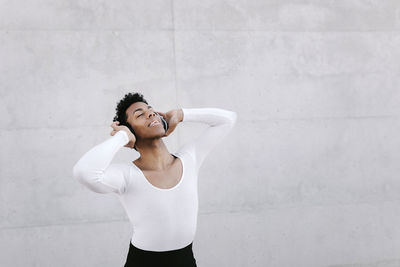 Young woman standing against wall