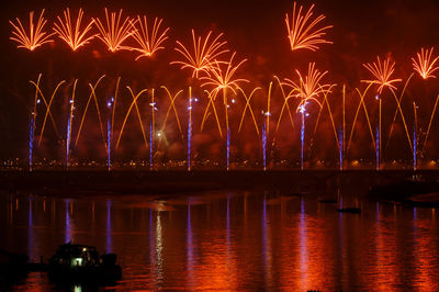 Firework display over river at night