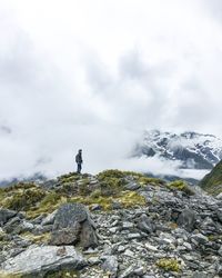 Man standing on mountain against sky