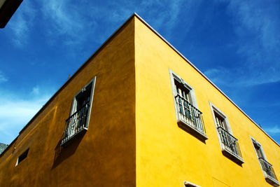 Low angle view of yellow building against sky