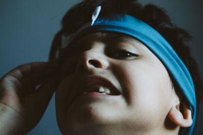 Close-up portrait of boy at home with headband