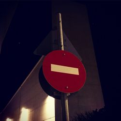 Low angle view of road sign at night