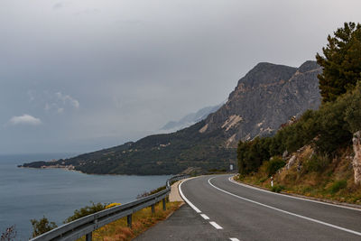 Road by mountain against sky