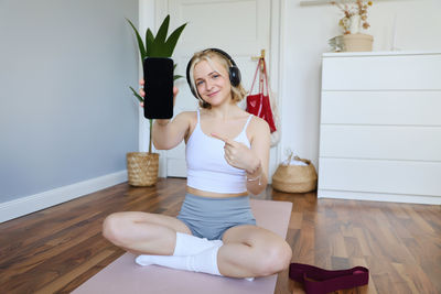 Full length of young woman exercising in gym