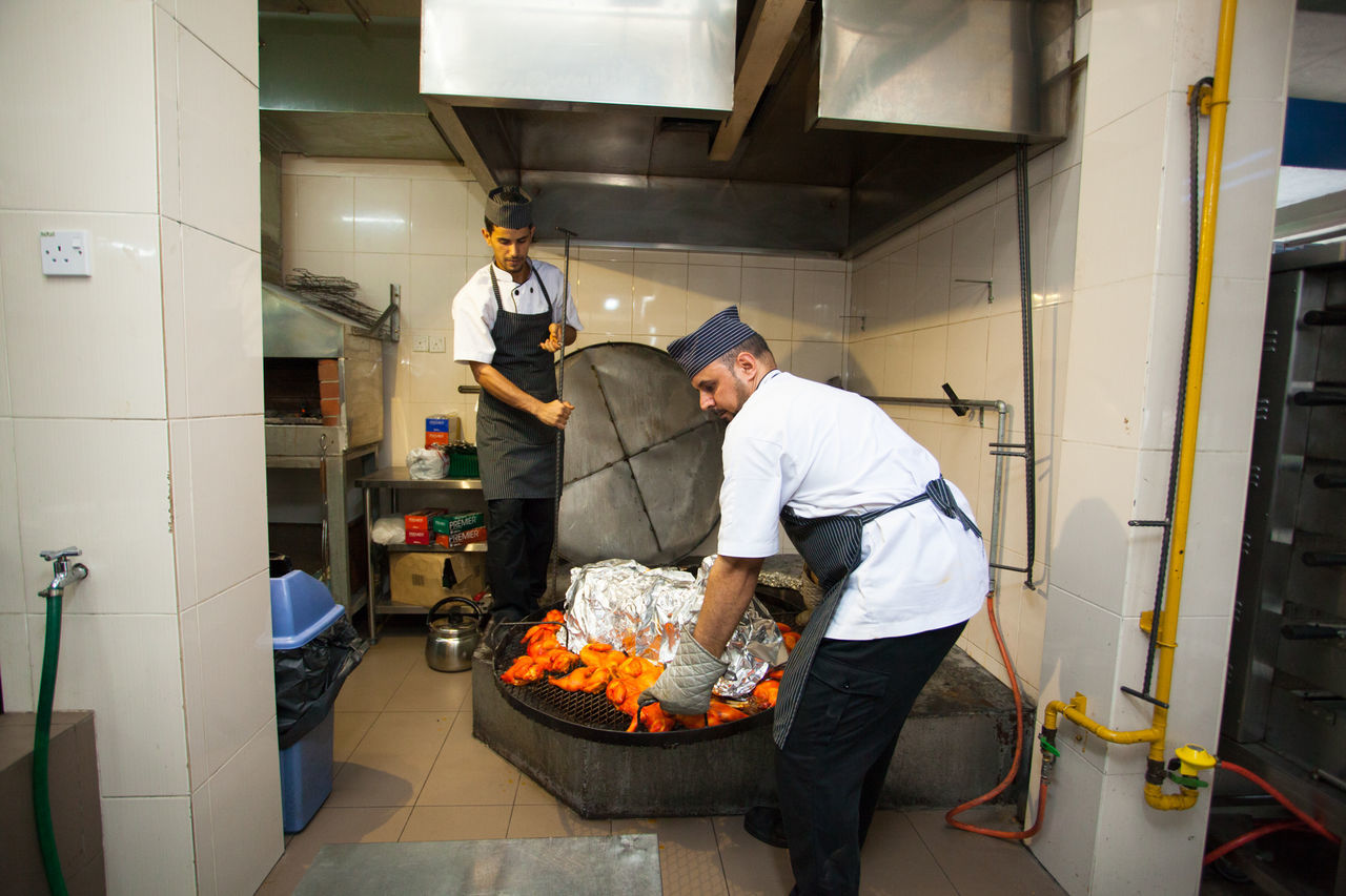 MAN PREPARING FOOD IN KITCHEN