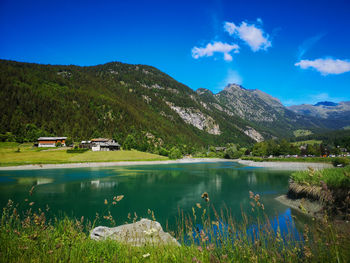 Scenic view of lake and mountains against blue sky