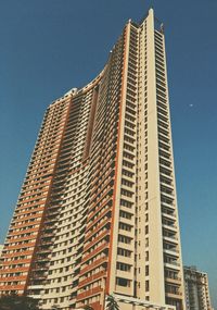 Low angle view of modern buildings against clear blue sky