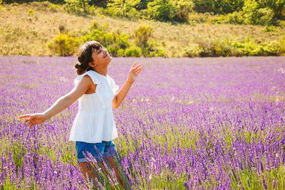 Rear view of woman with arms raised on field