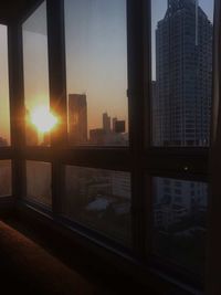 Modern buildings in city against sky during sunset