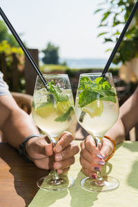 Close-up of hand holding drink on table