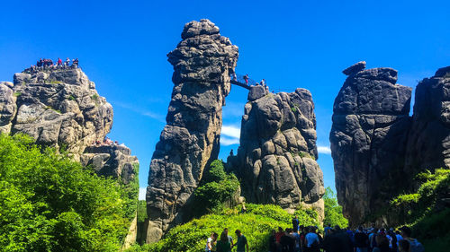 Low angle view of rock formations against clear blue sky