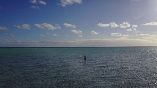 Man in sea against sky at beach