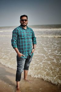 Full length of young man standing at beach