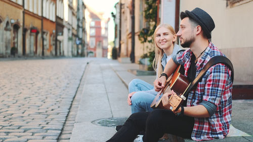 Young couple kissing on street in city