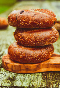 Stack of three blueberry bagels on small olive wood cutting serving board