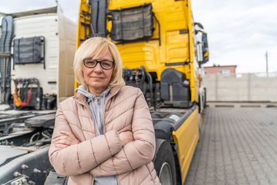 Portrait of mature woman standing by semi truck