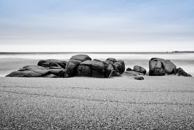 Rocks on beach against sky