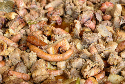 Different types of deep fried meat pieces and sausages, in display for sale at a street food market